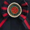 Harrods 手提包精美玫瑰花結胸針特寫，包含條紋緞帶、珍珠感珠飾與金色字母圖案